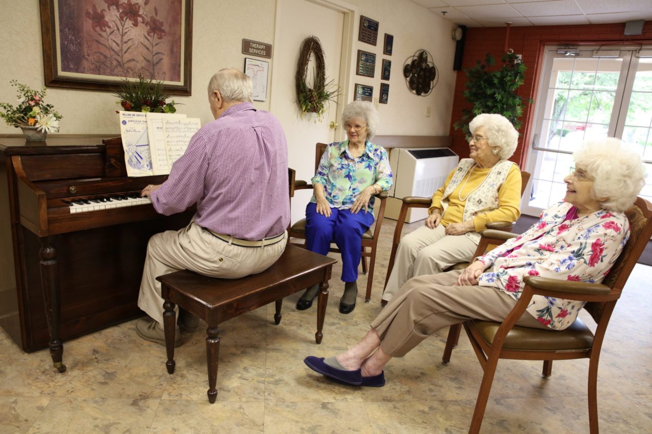 elderly-man-playing-piano-three-elderly-woman-listening