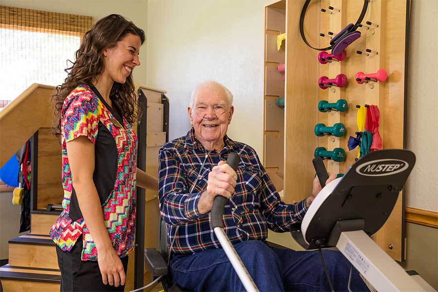 rehab-trainer-and-elderly-man-on-machine