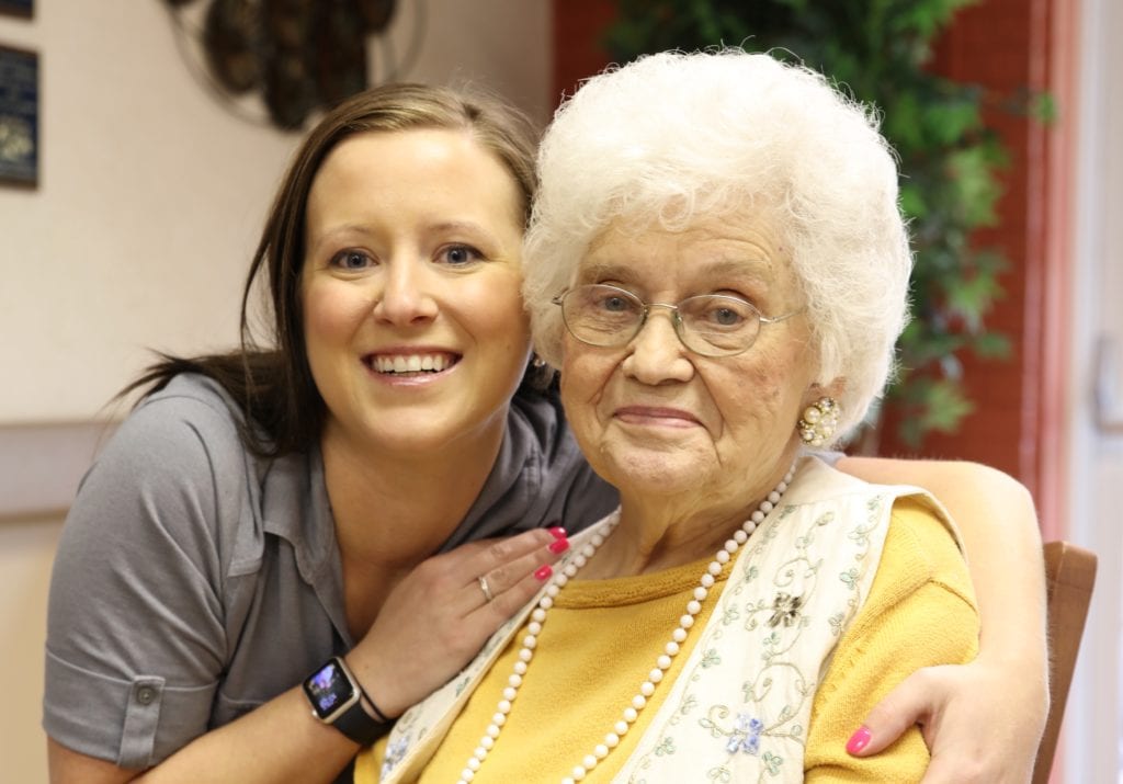 staff-and-elderly-woman-in-yellow-sitting